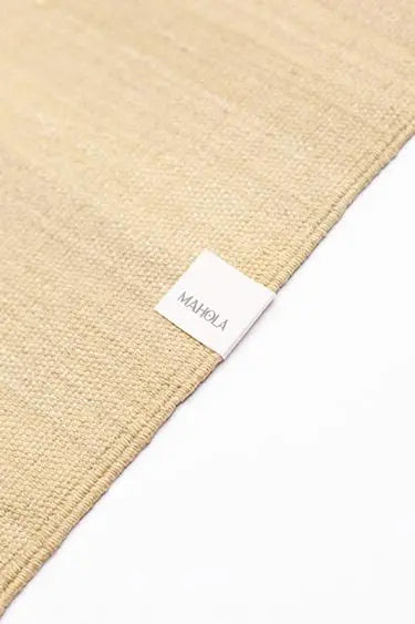 Étiquette de la marque Mahola sur le tapis de yoga beige